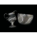 A silver pedestal milk jug with twist reeded decoration and double veloupe handle, indistinct marks,