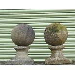 A pair of reconstituted stone spheres on plinths, height 39cm, width 22cm.