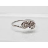 A platinum and diamond crossover ring - A platinum ring set two diamonds, each of ?? cts