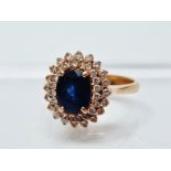Sapphire and diamond ring - A high carat gold ring set a faceted sapphire, length 8mm surrounded