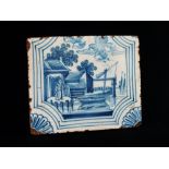 Delft - A blue and white tile depicting a figure at the water's edge, 10.5 x 13cm.