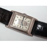 Kendal & Dent, London - A white metal tank cased gentlemans wristwatch with a leather bracelet.