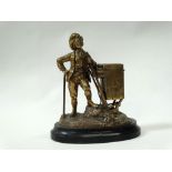 19th century bar top striker - A gilt brass figure of an 18th century man leaning on a box, the