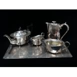 A silver plated four footed tea service with associated hot water jug and a twin handled tray with