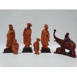 Oriental hardwood carvings - A boxwood group of three larger female figures on squared hardwood
