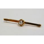 A 9ct. hallmarked bar brooch set a diamond of 0.3ct approximately, marked A.J.H., length 4.5cm, in