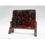 A Chinese circa 1900 soapstone table screen decorated with buildings and trees in a hillside