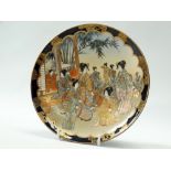 Satsuma - A shallow dish gilt decorated with geishas in a garden pavilion, seal mark to base,