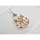 Art Nouveau - A 9ct gold pendant with oval facet cut peridot, diamond chips and baroque drop