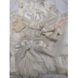 LINENS - Early 20th century christening gown and antique dolls clothes - A silk and lace jacket, a