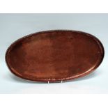 Hugh Wallis Arts and Crafts copper - A large planished oval tray with ropetwist border, monogrammed,