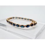 18ct gold, sapphire and diamond tennis bracelet - A .750 gold tennis bracelet set twenty two oval