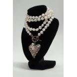 Pearls - A long row of freshwater pearls with a silver catch and a silver puffy heart motif by