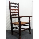 A single Yorkshire ash ladder back carver - A six splat open arm rush seated chair, height 109cm.