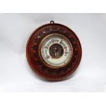 19th century aneroid barometer - With circular stained oak carved case, diameter 21.5cm.