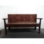 A 17th century oak four panel settle with open shaped arms and plank seat, height 92cm, width 169.