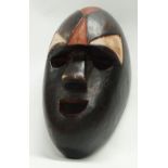 Ethnographic native tribal - A dark patina polychrome carved wooden face mask, height 34.5cm,