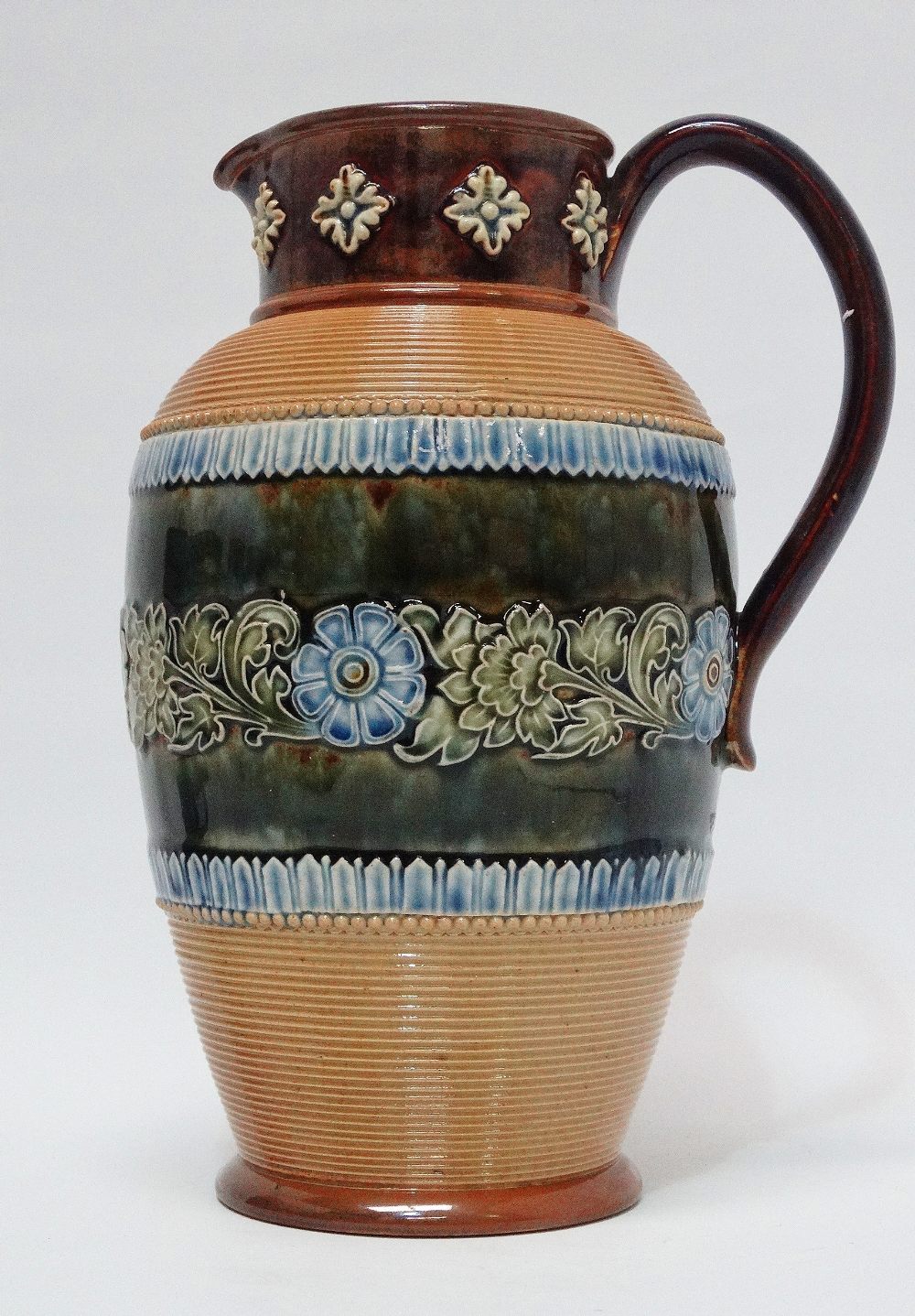 Doulton Lambeth England - A tall handled jug with bas relief, 8852 and stamped maker's mark 'ha'