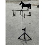A black painted wrought iron wind vane modelled as a horse, height 155cm, width 79cm.