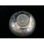 An Islamic silver bowl with engraved decoration, the base inset with an Iranian silver coin,