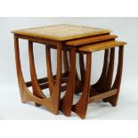 G-Plan Red - A nest of three graduated quadrille occasional tables of teak form, the largest with