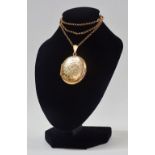9ct Gold - An oval double locket, height 3.34cm, on a 9ct gold chain, chain length 48cm, total