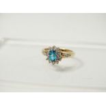 9ct Gold Ring - A 9ct gold ring with white gold mount set a topaz coloured oval stone flanked by