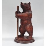 Black Forest bear - A standing bear with glass eyes on a circular carved base, height 32cm.