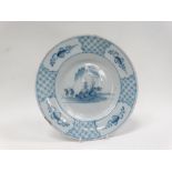 18th century Delft - A blue and white plate circa 1750, decorated with figures by a river island