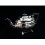 Silver - A silver teapot raised on four ball feet with ebony handle and finial, London 1932,