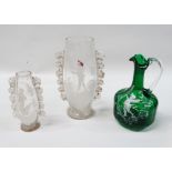 Mary Gregory - A green glass jug painted with a cherub amongst foliage, height 20cm, together with