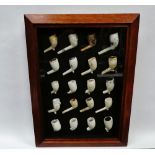 18th/19th century clay pipes - A framed and glazed collection of twenty clay pipe heads, overall