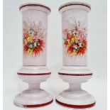 A Victorian pink opaque glass garniture - the pair of cylindrical vases decorated with flowers and