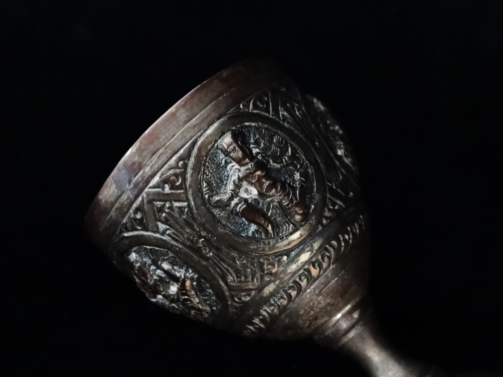 An Indian silver double egg cup - Repousse decorated with deities, 10cm (high), together with a pair - Image 5 of 7