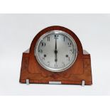 An Art Deco style walnut mantel clock - the silver dial set out in Arabic numerals with a tree train