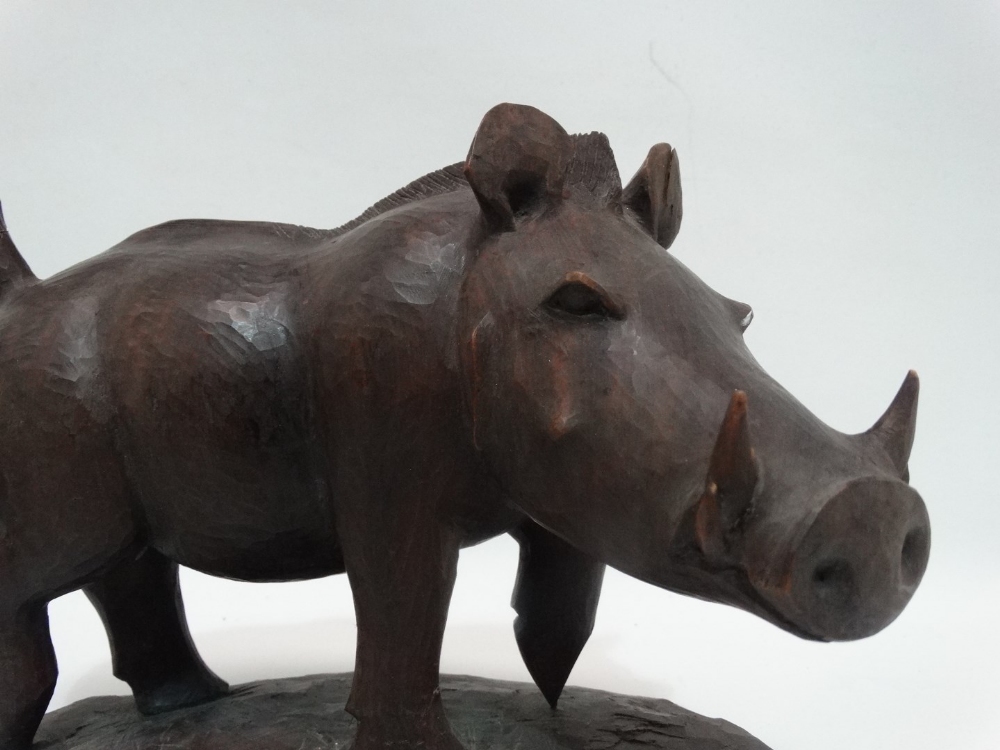 A carved exotic hardwood model of a warthog - standing on a naturalistic base, signed Nganga, height - Image 2 of 5
