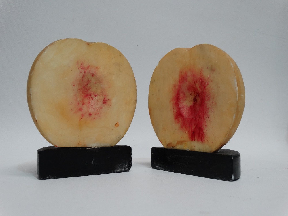 A pair of composite bookends - modelled as a sliced peach, height 10cm.