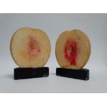 A pair of composite bookends - modelled as a sliced peach, height 10cm.