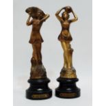 A pair of Art Deco spelter figures - one standing holding a fan, raised on an ebonised circular