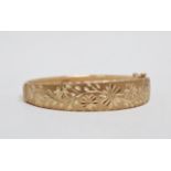 A 9ct gold Italian bangle - engraved with flowers and foliage, weight 9.5g.