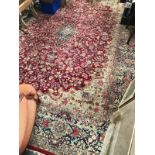 A Kerman hand knotted carpet - with foliate scroll decoration on a burgundy ground and within