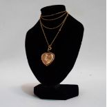 A locket - heart shaped and engraved with foliage, on a fine 9ct yellow gold chain,