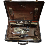 A 20th century leather travelling case - The fitted interior with silver backed mirror and brushes