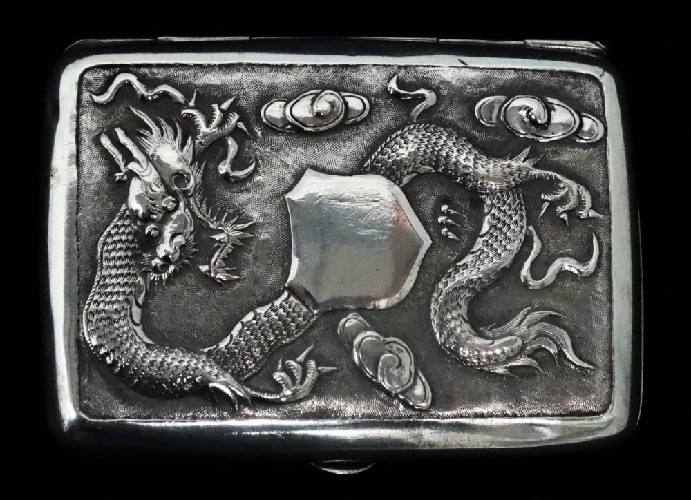 An early 20th century Chinese white metal cigarette case - decorated with a dragon amongst clouds,