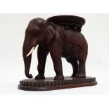 A late 19th century Anglo Indian hardwood stand - carved in the form of an elephant with bone tusks,