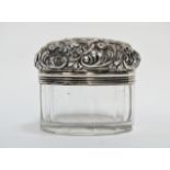 A silver topped container by Mappin & Webb - London 1897, the lid of foliate design on a clear glass
