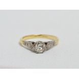 A diamond single stone dress ring - with diamond set shoulders on 18ct yellow gold band, size M,
