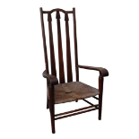 An Arts and Crafts oak open armchair in the manner of Charles Francis Annesley Voysey - with arrow