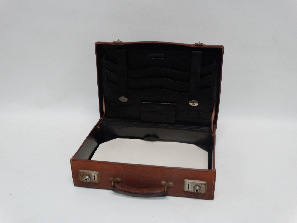 A 20th century tan leather writing case - in the form of an attache case, the fitted interior