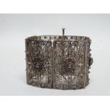A late 19th century oriental white metal cuff - comprising six articulated floral filigree panels,
